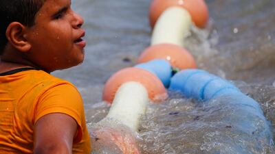 Ghamies Abdelrahman, 13, a visually impaired child, enjoys the water at Al Mandara beach. Reuters