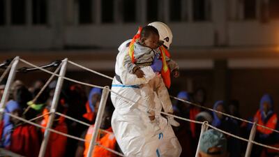 A rescuer carries a migrant child, intercepted off the coast in the Mediterranean Sea, after arriving on a rescue boat at the port of Malaga. REUTERS