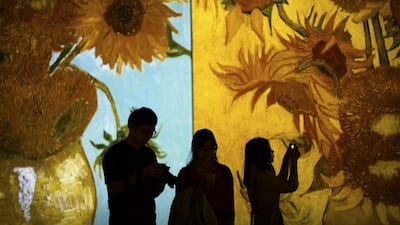Visitors take photos as paintings by Vincent van Gogh are projected during an exhibition at a shopping mall in Beijing. The 'Van Gogh Alive' exhibit includes over 3,000 images of the Dutch painter's work as part of a multimedia display. Mark Schiefelbein / AP Photo