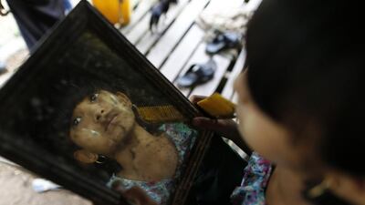 Cho Mar, an 11-year-old who hid in the jungle with her mother during an attack by Buddhist gangs, inspects the thanaka she had just put on her face at Thapyuchai village, outside of Thandwe in the Rakhine state. Soe Zeya Tun / Reuters