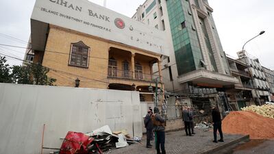 Iraqis check the site of an explosion outside Cihan Bank in the Karrada district of Iraq's capital Baghdad, after two banks in the city were targeted with explosive devices late on Sunday injuring two people. AFP