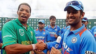 South Africa's Makhaya Ntini, left, shakes hands with India's captain Mahendra Singh Dhoni, right, at the end of the Twenty20 match at the Moses Mabhida stadium in Durban.