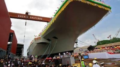 Employees of Cochin Shipyard stand beside India's Aircraft Carrier P-71 "Vikrant" built for the Indian Navy at its launch in the southern Indian city of Kochi.