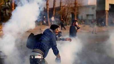 An Egyptian protester throws back tear gas canisters during clashes with riot police near Cairo’s Tahrir Square.