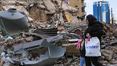 A woman and her daughter pass a building that was damaged by an Israeli air strike in Beirut's southern suburb of Dahieh, on April 20, 2026. Getty Images