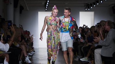 Singer Miley Cyrus walks with designer Jeremy Scott after a presentation of his Spring/Summer 2015 collection during New York Fashion Week on September 10, 2014. Lucas Jackson / Reuters