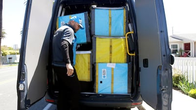 A delivery guy steps down from the back of the van as he makes deliveries for Amazon during the outbreak of the coronavirus in California. Reuters