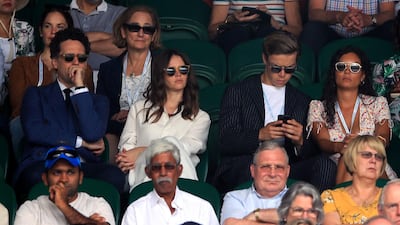 Charles Guard, Felicity Jones, in Ralph Lauren, and Will Poulter (centre left to right) on day seven of the Wimbledon Championships at the All England Lawn Tennis and Croquet Club. PA