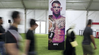 UFC fans walk passed a poster of Dustin Poirier. Chris Whiteoak / The National