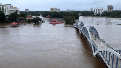 India residents stand on the shore as Periyar river flooded. AFP