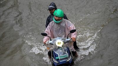 A motorcyclist rides through a flooded street. AFP