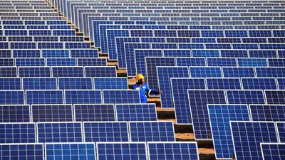 A worker walks between solar panels at Centragrid power plant in Nyabira, Zimbabwe, June 23, 2020. REUTERS