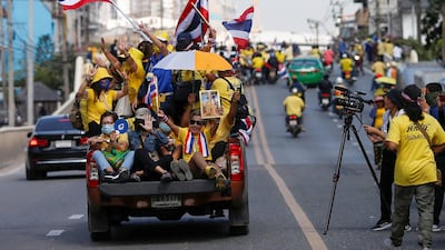 Royalists hold national flags while travelling towards a rally in front of parliament to protest the proposed motion to amend the constitution on articles related to the monarchy, in Bangkok, Thailand. Reuters