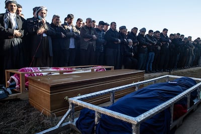 Men in Ranya, Iraq, pray over the bodies of three migrants who died in a boat bound for Britain. Getty Images
