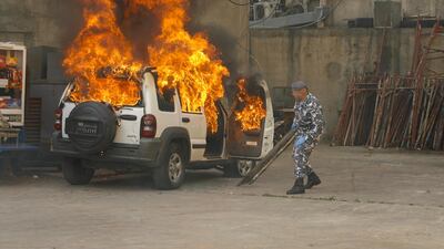 A Lebanese policeman reacts as his jeep is engulfed in flames during clashes between protesters and Lebanese soldiers in the northern port city of Tripoli. AFP