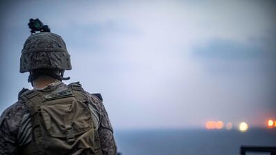 Marines observe nearby vessels passing through the Strait of Hormuz. Reuters