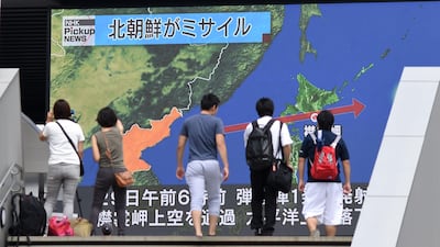Journalists film as pedestrians walk in front of a huge screen displaying a map of Japan, right, and the Korean Peninsula, in Tokyo. Toshifumi Kitamura / AFP