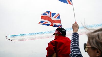 Spectators wave British Union flags, also known as a Union Jacks, as they watch a fly past as part of the the D-Day service on Southsea Common, in Portsmouth. Bloomberg
