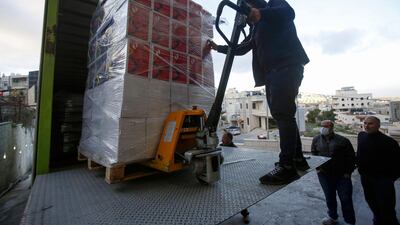 Palestinian workers unload food supplies to deliver to a hotel under quarantine in the West Bank city of Bethlehem on March 7, 2020, a day after a lockdown on the biblical city was announced upon discovering the first Palestinian cases of the disease. AFP