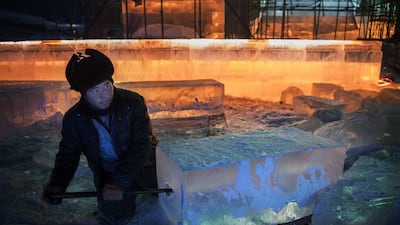 A Chinese labourer cuts into a large ice block to place lights as he works with others to finish large ice sculptures in preparation for the Harbin Ice and Snow Festival in Harbin, China. Getty Images