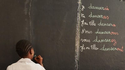 Seven-year-old Astau Diouf, 1st grade, writes down the phonetic spelling of 10,000 Senegalese Francs in an attempt to impress her classmates with a correct answer. Naser Al Wasmi / The National