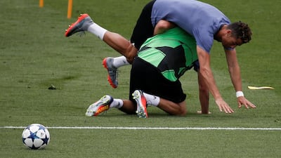 Cristiano Ronaldo falls over Fabio Coentrao during the training session. Sergio Perez / Reuters