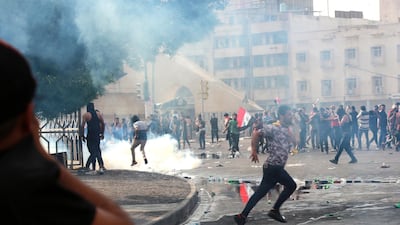 Iraqi protesters run for cover amid tear gas fired by policemen during a demonstration at Tahrir Square, central Baghdad. EPA