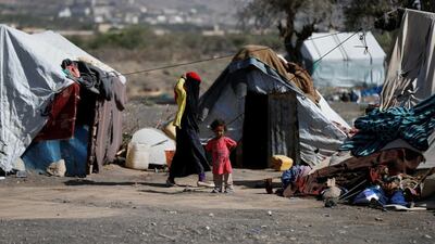 A Yemeni woman walks past a child at a camp for people displaced by the war, near Sanaa, on April 25, 2017. Khaled Abdullah / Reuters