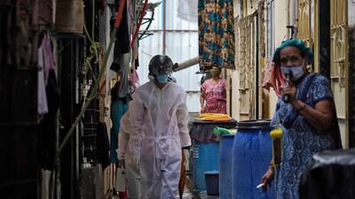 A worker from Bharatiya Jain Sanghatana, a non-governmental organisation, walks in an alley to screen the residents during a check-up campaign for the coronavirus disease (COVID-19) in a slum Mumbai, India, July 23, 2020. Reuters