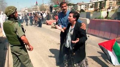 Palestinian legislator Hanan Ashrawi (right) argues with an Israeli soldier at the Ar-Ram checkpoint near the West Bank town of Ramallah, during a 2001 protest by Palestinian women against the Israeli closure of the Palestinian territories.
