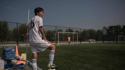 A student stands on the sideline of a women's football training session at the Pyongyang International Football School. Ed Jones / AFP