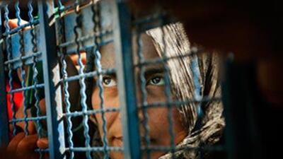A Palestinian woman waits to receive aid at a United Nations food distribution centre in Gaza City, Sunday, Jan 25 2009. International aid organizations and the United Nations say truce talks' priority must be to ensure the reopening of Gaza to provide relief and reconstruction help for its 1.4 million people. (AP Photo/Kevin Frayer) *** Local Caption *** AKCF106_APTOPIX_MIDEAST_ISRAEL_PALESTINIANS.jpg