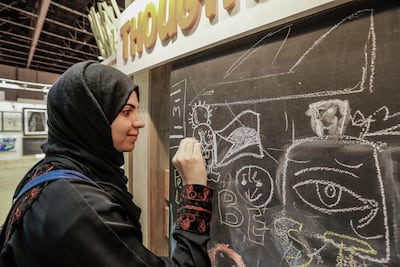A Palestinian attendee draws Handala at World Art Dubai. Victor Besa / The National