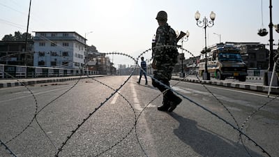 In this photo taken on August 5, 2019, Indian paramilitary troopers stands guard near a barbed fence wire as they block a road during a curfew in Srinagar. AFP