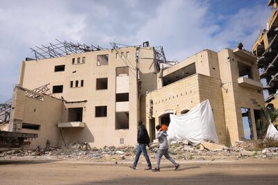 Men walk past the heavily-damaged Roots Hotel in western Gaza city. AFP