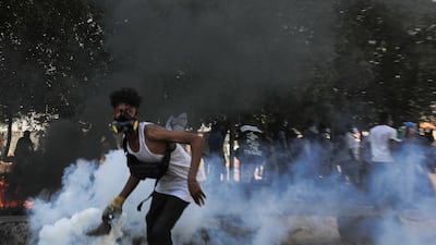 A Sudanese protester attempts to throw back a tear gas canister during clashes with security forces at an anti-coup protest, in Khartoum, Sudan, 09 January 2022. Security forces fired tear gas to disperse protesters gathering in Khartoum and attempting to march towards the presidential palace, as part of the continuing protesting movement against a military coup in October 2021. The protest was organized a day after the UN envoy for Sudan said the international group will invite different parties for talks in Sudan to end the crisis. EPA