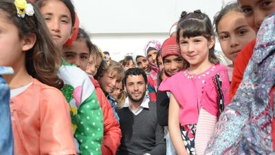Surrounded by his students, Ghasan Al Hasan, a refugee who escaped Homs four years ago teaches grades 3 to 7 to more than 400 students in the UAE-Jordanian camp and even gives seminars in Al Zaatari camps to teachers. Naser Al Wasmi / The National