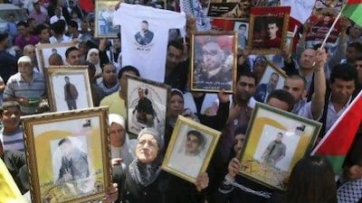 Palestinians in the West Bank city of Nablus hold photographs of prisoners jailed in Israel, during a rally to mark the annual prisoners' day yesterday.