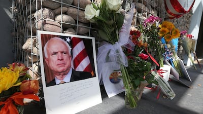 Items and personal notes are left outside the office of Sen. John McCain, as people pay their respects to the late Arizona senator. Getty Images
