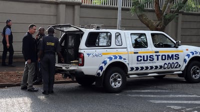 Members of the South African Asset Forfeiture Unit and other law enforcement agencies arrive to search the Gupta family compound. AFP