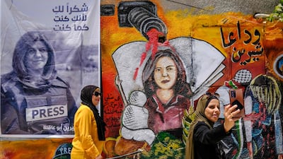 Two women take a selfie on May 19 at an art exhibition honouring Palestinian journalist Shireen Abu Akleh in Jenin city in the occupied West Bank. AFP