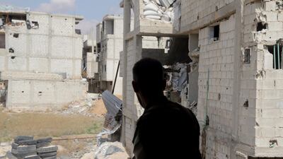 A Syrian government soldier stands near damaged buildings of the besieged rebel-held Eastern Ghouta on February 28, 2018. Youssef Badawi / EPA