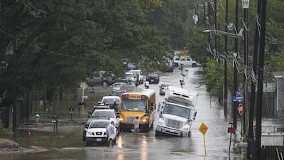 A man tries to direct a school bus on the flooded Hopper Rd. on September 19, 2019 in Houston, Texas. Getty