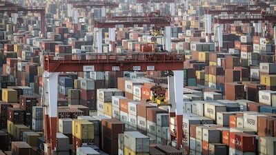 Shipping containers next to gantry cranes at the Yangshan Deepwater Port in Shanghai. China's trade surplus hit $535bn last year, a 27% increase on 2019. Bloomberg