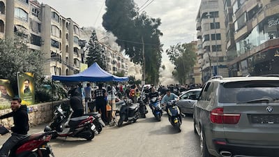 People rush for cover as smoke rises from the site of an Israeli strike in southern Beirut. AFP