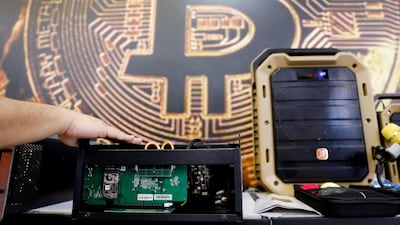 A cryptocurrency mining computer is seen in front of Bitcoin logo. A university research papers says there is evidence of manipulation of cryptocurrencies. Reuters