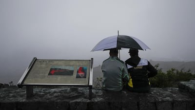 A couple sits on the edge of the Jaggar Museum's overlook to view Kilauea's summit crater in Volcanoes National Park, Hawaii. Jae C Hong / AP Photo