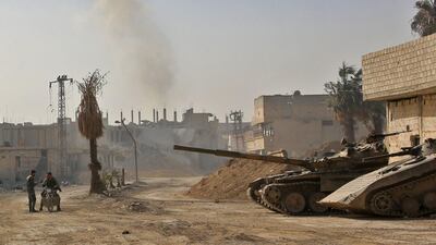 Smoke billows in the background as Syrian army tanks are seen in the former rebel-held area of Beit Nayem in the Eastern Ghouta region on the outskirts of the capital Damascus on March 6, 2018. AFP