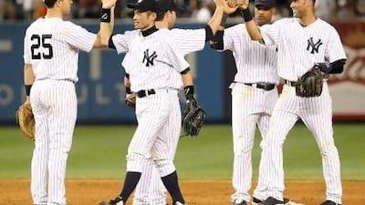 New York Yankees' Ichiro Suzuki, second from left, celebrates with teammates Mark Teixeira, left, Jayson Nix, third from left, Robinson Cano, second from right, and Derek Jeter after a baseball game against the Boston Red Sox at Yankee Stadium on Friday.