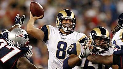 Sam Bradford, the St Louis quarterback who was the top selection in this year's draft, throws under pressure from New England's Ron Brace, left, during the Rams' exhibition victory on Thursday night.